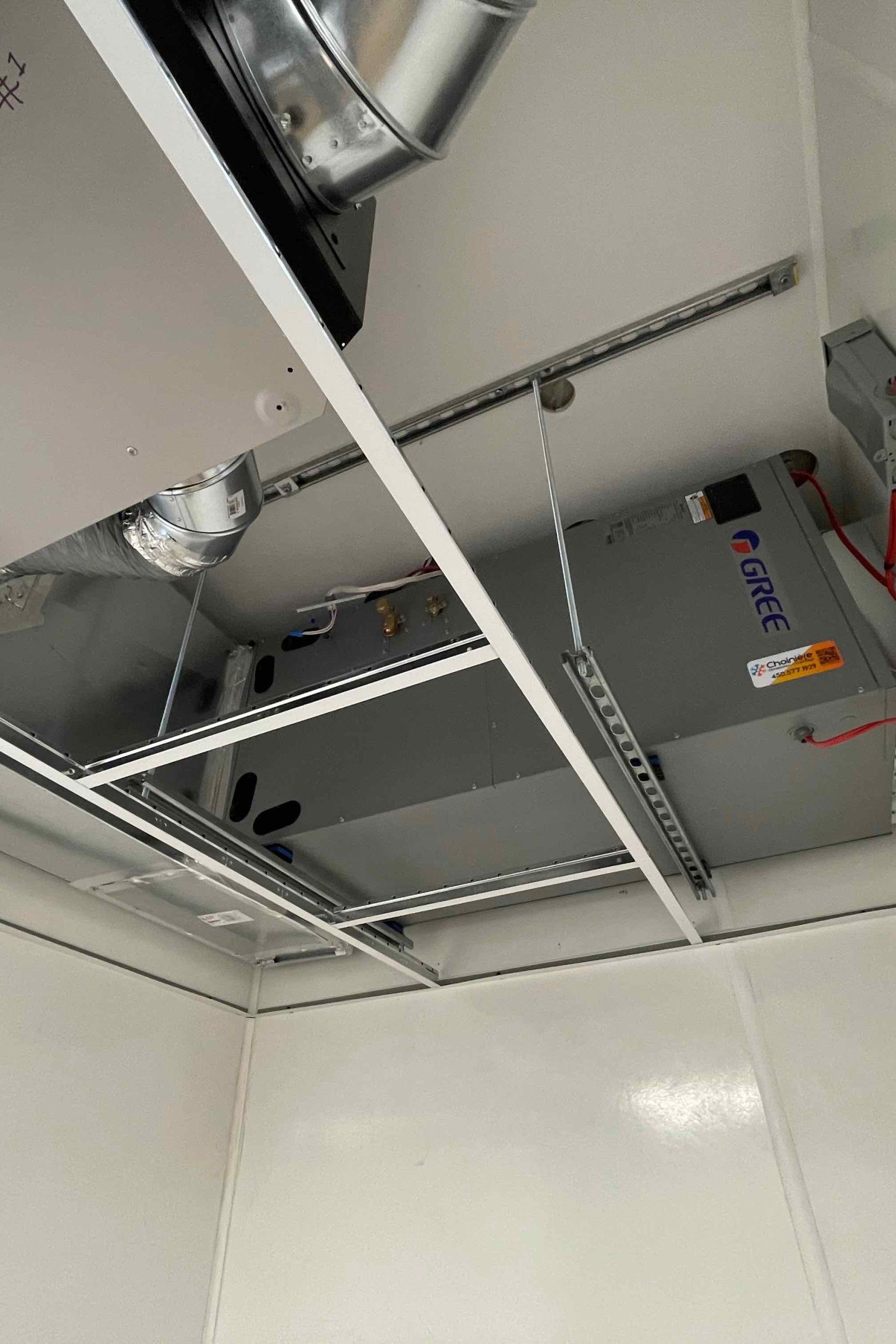 Thermopompe GREE UNIX installée dans un plafond suspendu dans un local commercial à Granby