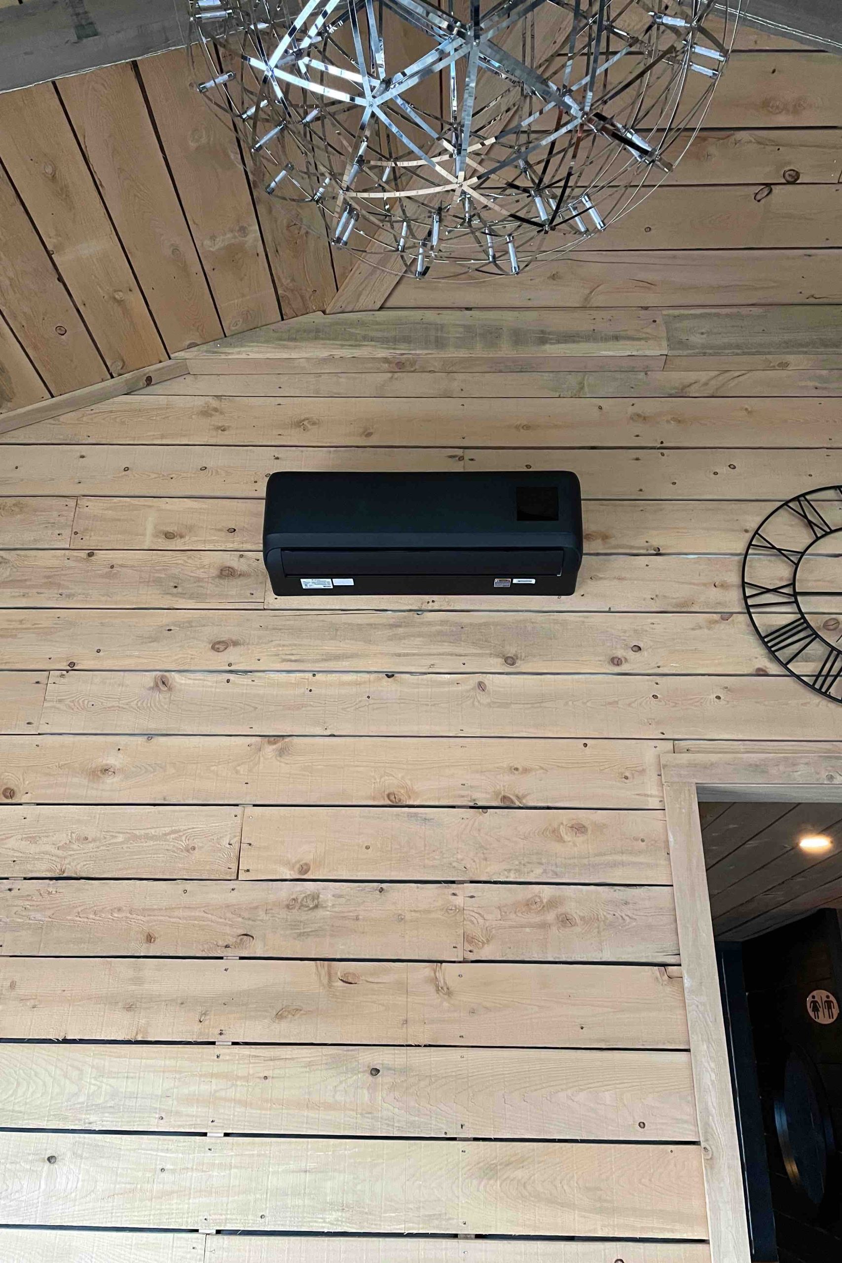 Thermopompe murale GREE noire installée dans une salle de réception à Knowlton